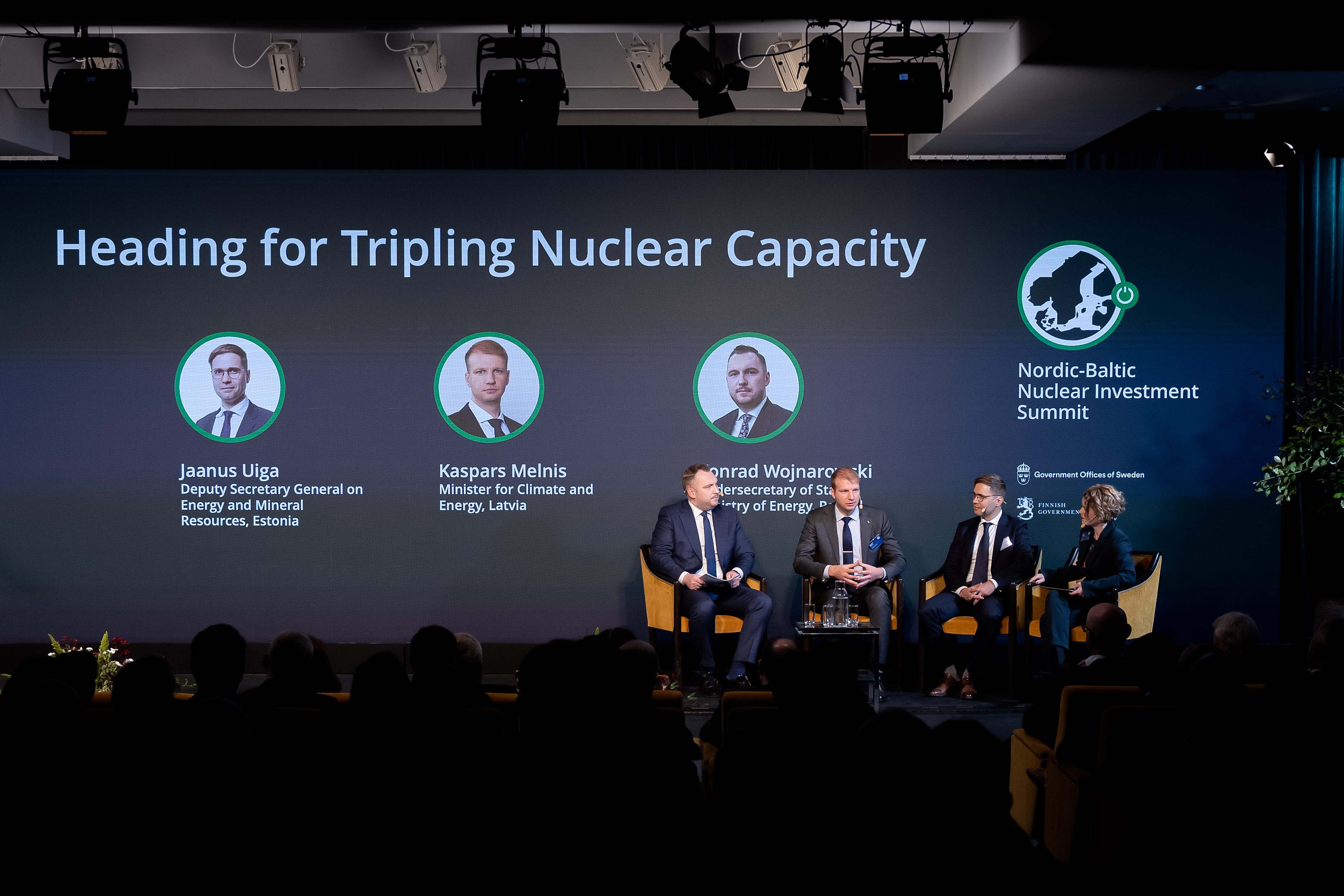 Three ministers sitting down in armchairs having a discussion with the moderator