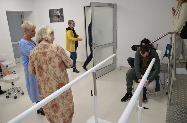 Anna Tenje and Camilla Waltersson Grönvall watch as a man performs rehabilitation exercises.