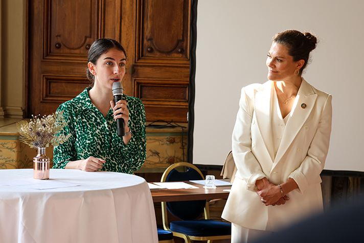 Minister speaking and Crown Princess listening.