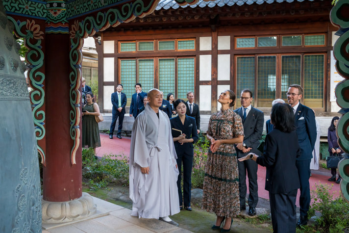 Crown Princess Victoria, Prince Daniel and Minister for Infrastructure and Housing Andreas Carlson standing near temple.