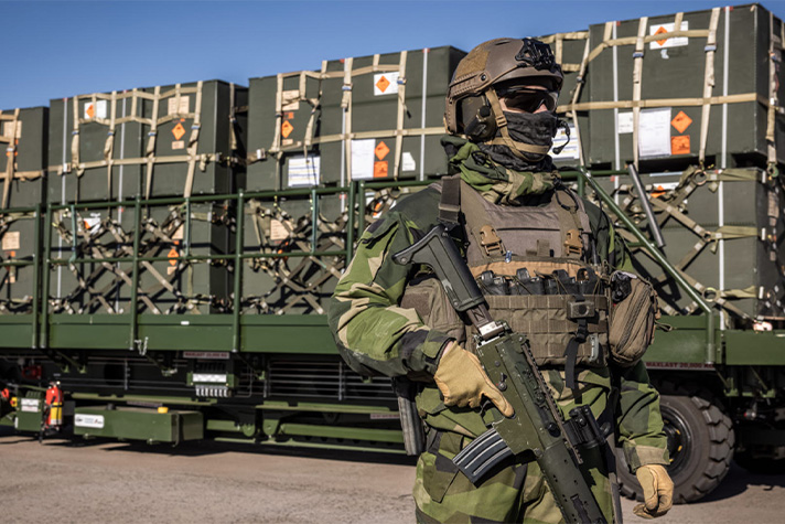 Soldier standing in front of a military transport.